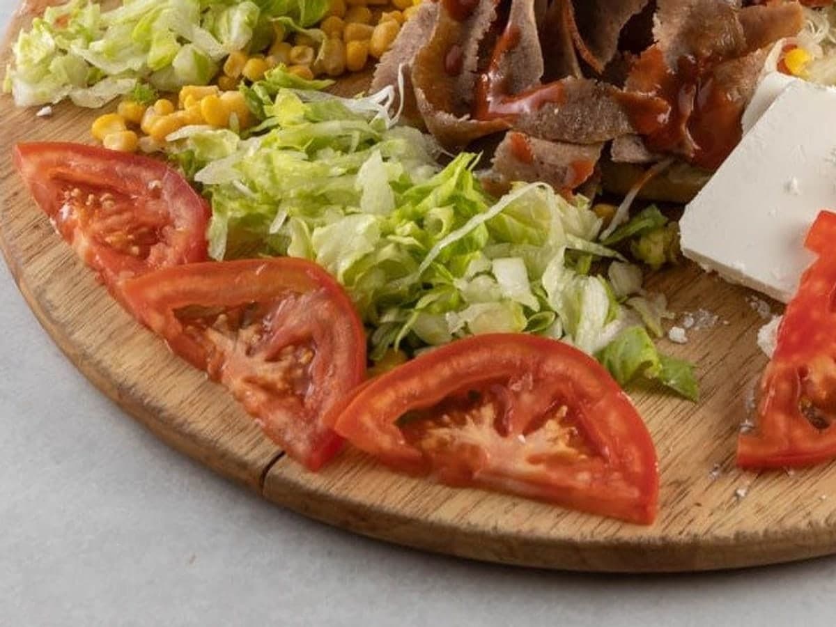 Kebab salata bez kruha: meso s umakom, zelena salata, kukuruz, rajčica i sir na drvenoj dasci