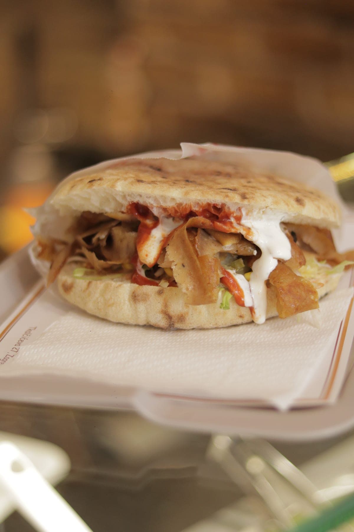 Kebab u lepinji s mesom, umakom i salatom, izbliza na pultu