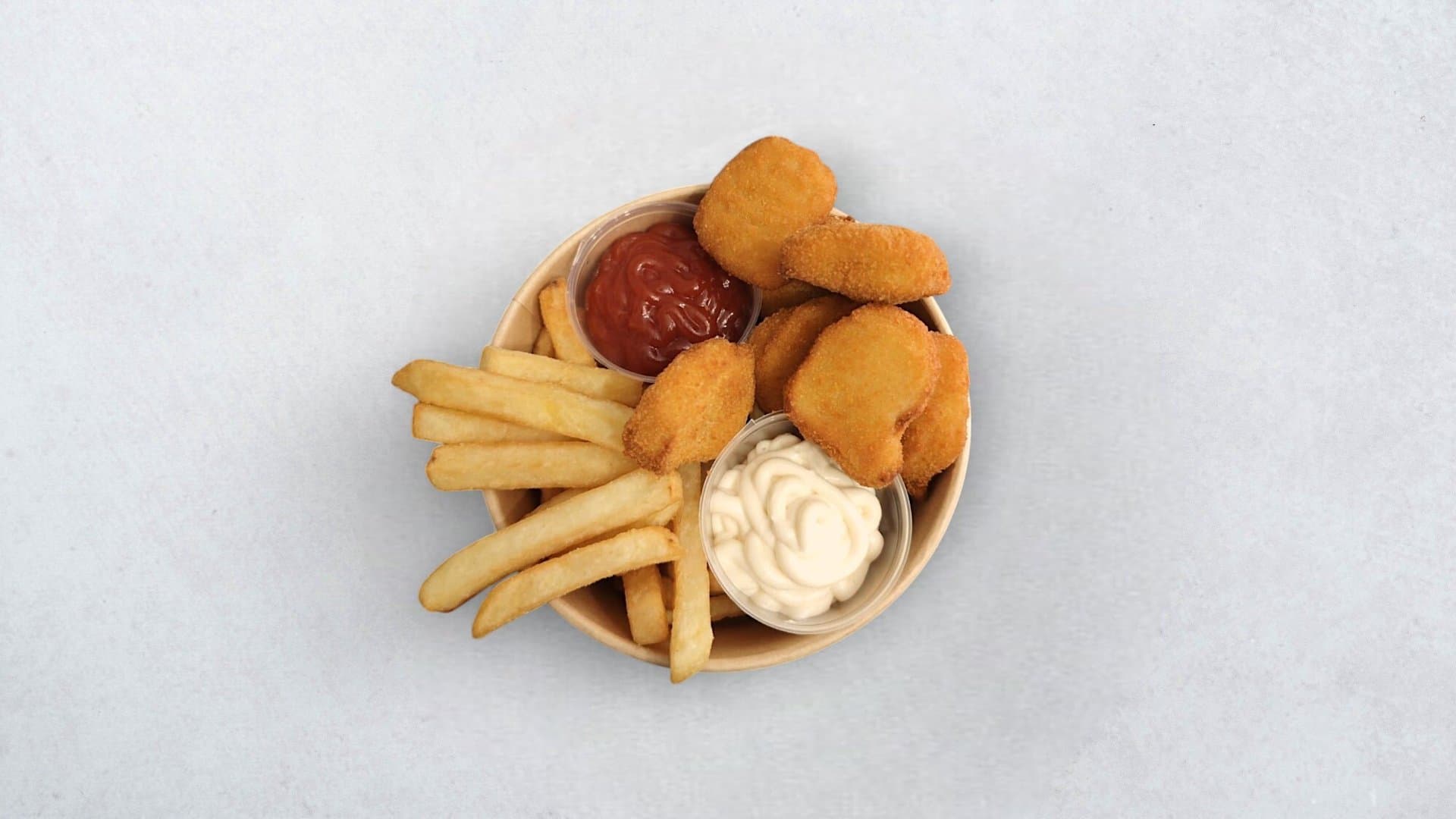 Nuggetsi s pommes fritesom i umacima u papirnatoj zdjelici