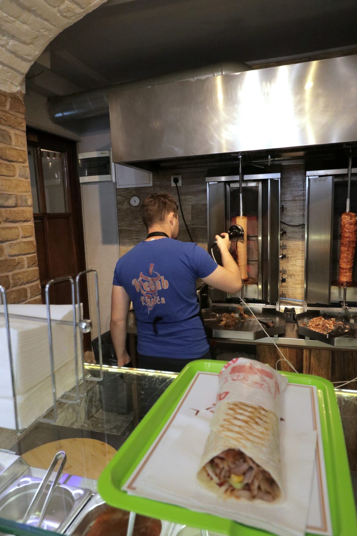 Majstor reže meso s ražnja u Kebab Tkalča, a tortilja čeka na pultu